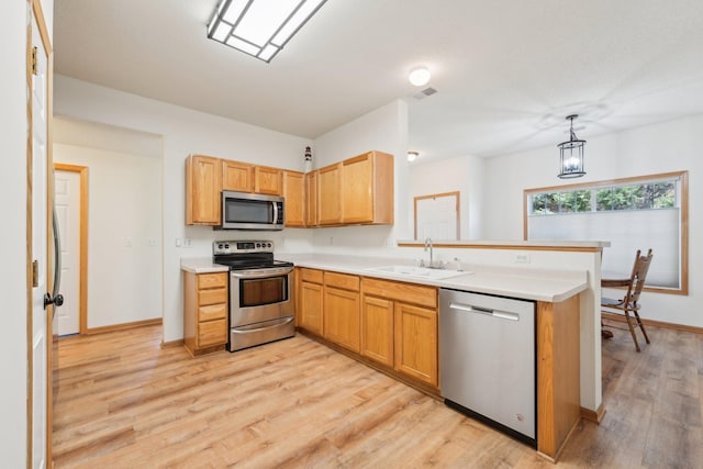 6509 154th St W, Apple Valley, MN 55124 - kitchen featuring appliances with stainless steel finishes, a sink, a peninsula, light wood-style floors, and light countertops