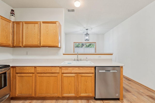 6509 154th St W, Apple Valley, MN 55124 - kitchen featuring appliances with stainless steel finishes, a sink, light wood-style flooring, light countertops, and a peninsula
