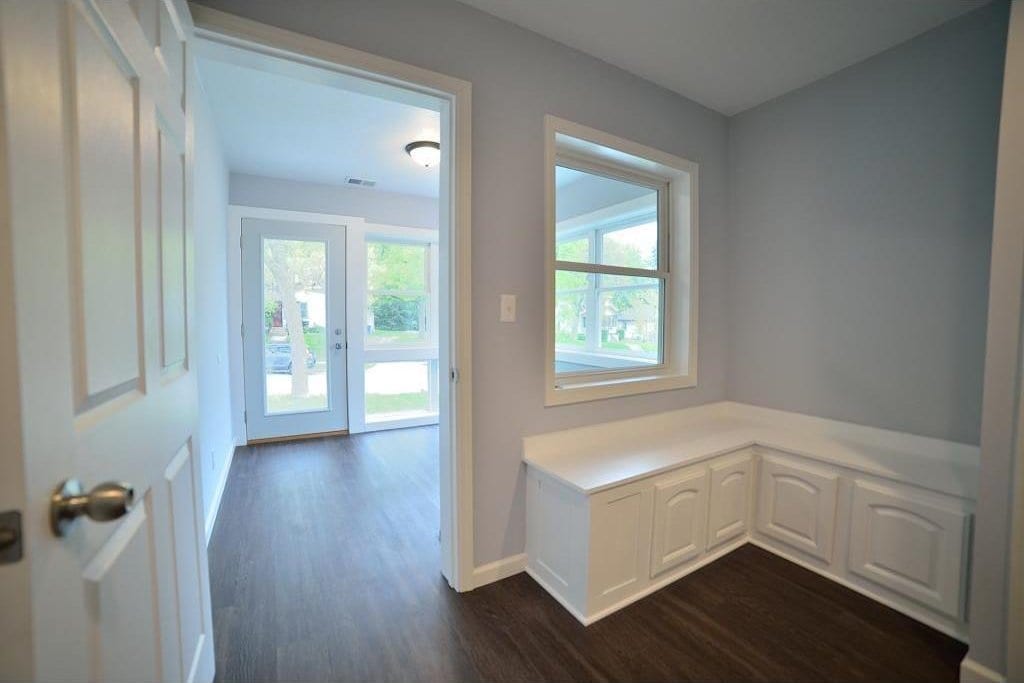 entryway with dark wood-type flooring and baseboards
