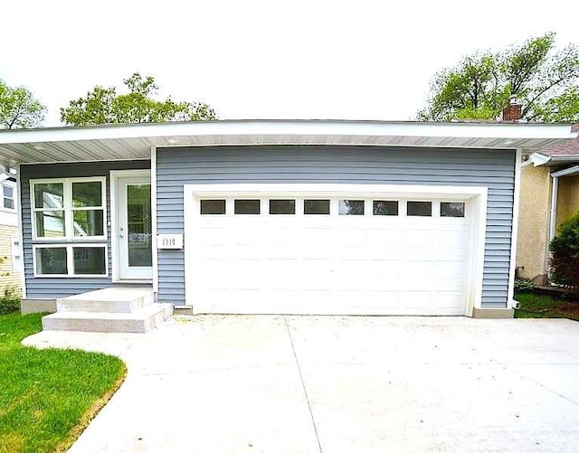 1310 Pacific St, Saint Paul, MN 55106 - view of front facade with driveway and a garage