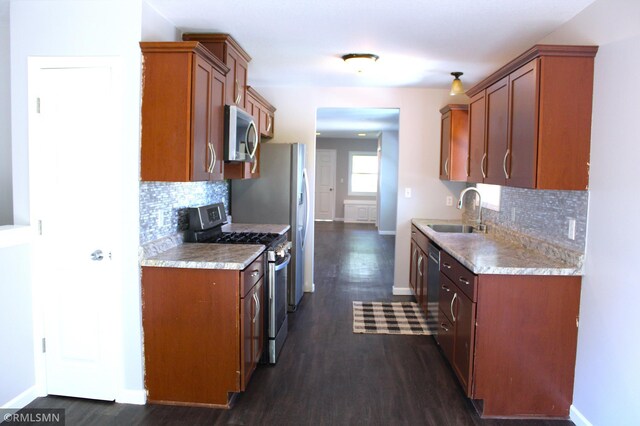 1310 Pacific St, Saint Paul, MN 55106 - kitchen with appliances with stainless steel finishes, a sink, baseboards, and decorative backsplash