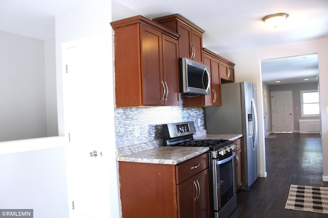 1310 Pacific St, Saint Paul, MN 55106 - kitchen featuring appliances with stainless steel finishes, dark wood-style flooring, tasteful backsplash, and brown cabinets