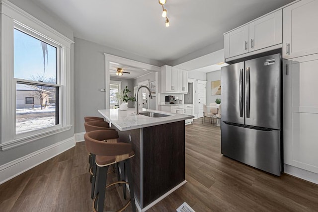 kitchen with freestanding refrigerator, a sink, white cabinets, and dark wood-style flooring