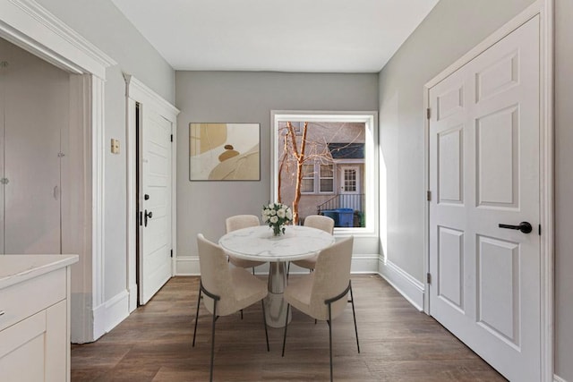 dining area featuring dark wood finished floors and baseboards