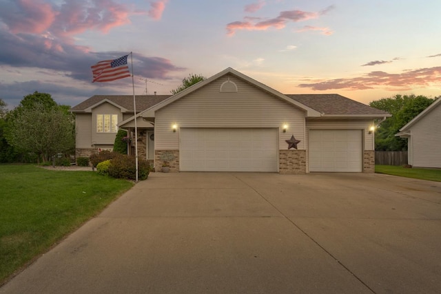 view of front of house with an attached garage, driveway, and a front lawn