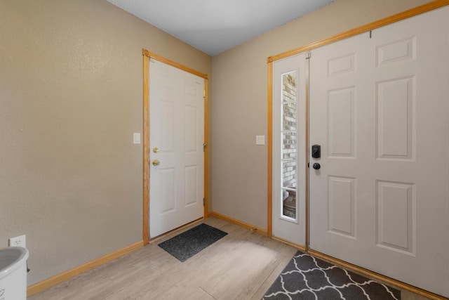 foyer featuring light wood finished floors and baseboards