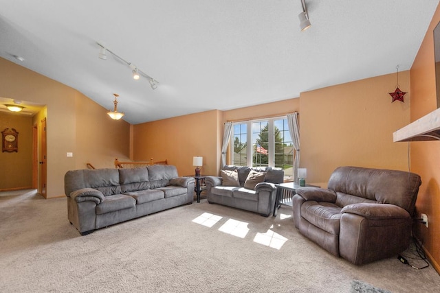 living room with rail lighting, lofted ceiling, and carpet flooring