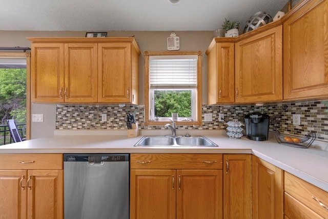 kitchen featuring stainless steel dishwasher, a sink, light countertops, and tasteful backsplash