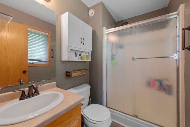 bathroom featuring a stall shower, toilet, and vanity
