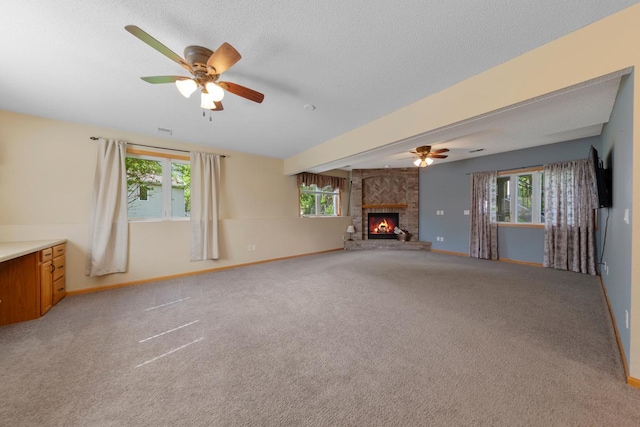 unfurnished living room with plenty of natural light, ceiling fan, and a textured ceiling