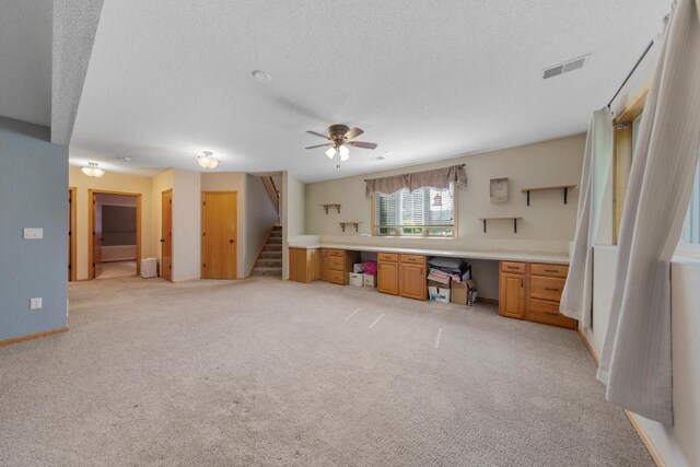 kitchen featuring ceiling fan, light carpet, a textured ceiling, and light countertops