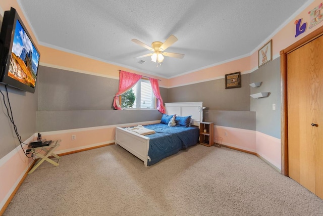 carpeted bedroom with a textured ceiling, ornamental molding, a ceiling fan, and baseboards