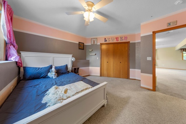bedroom with carpet floors, ceiling fan, a closet, and crown molding