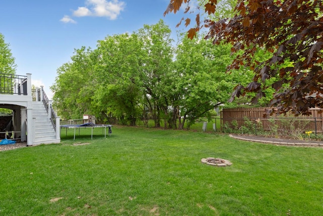 view of yard with a trampoline and stairs