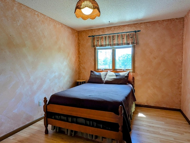 1401 5th St, Montevideo, MN 56265 - bedroom with light wood-type flooring, baseboards, a textured ceiling, and a textured wall