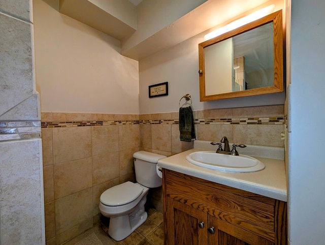 1401 5th St, Montevideo, MN 56265 - bathroom featuring a wainscoted wall, tile walls, toilet, vanity, and tile patterned floors