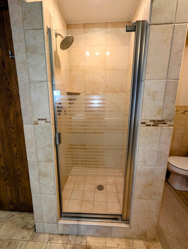 1401 5th St, Montevideo, MN 56265 - full bathroom featuring a shower stall, tile patterned flooring, tile walls, and toilet