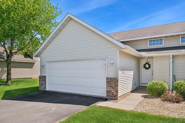 view of front of home with asphalt driveway, brick siding, a shingled roof, and a garage