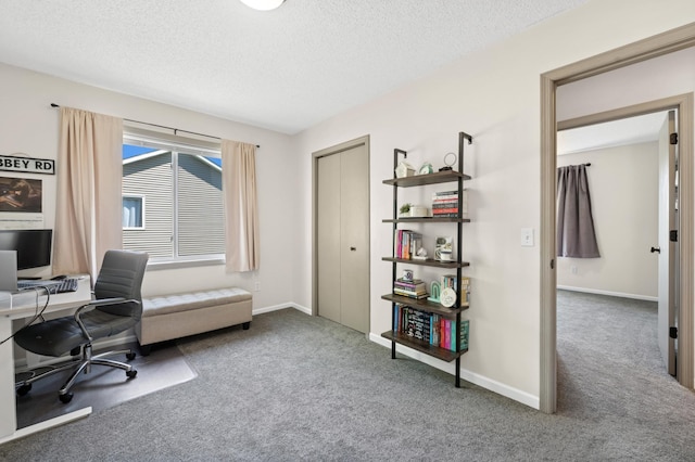 carpeted office space featuring a textured ceiling and baseboards