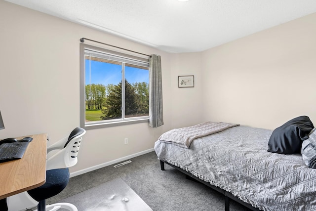 carpeted bedroom with baseboards and a desk