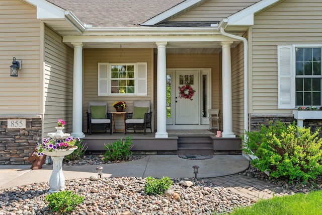 855 Elins Lake Rd SE, Cambridge, MN 55008 - view of exterior entry featuring covered porch, stone siding, and a shingled roof