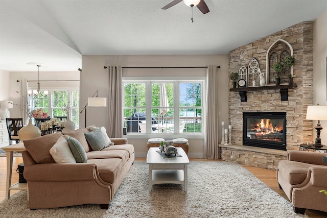 855 Elins Lake Rd SE, Cambridge, MN 55008 - living room with vaulted ceiling, wood finished floors, ceiling fan, a fireplace, and a chandelier