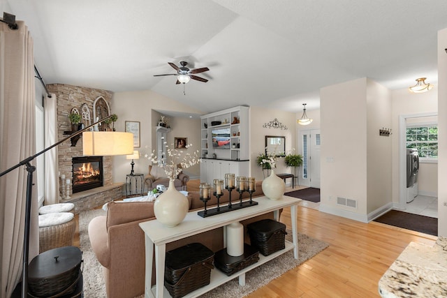 855 Elins Lake Rd SE, Cambridge, MN 55008 - living area featuring a ceiling fan, a stone fireplace, wood finished floors, vaulted ceiling, and baseboards