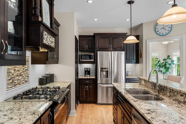 855 Elins Lake Rd SE, Cambridge, MN 55008 - kitchen with appliances with stainless steel finishes, a sink, light wood-style floors, dark brown cabinets, and a textured ceiling
