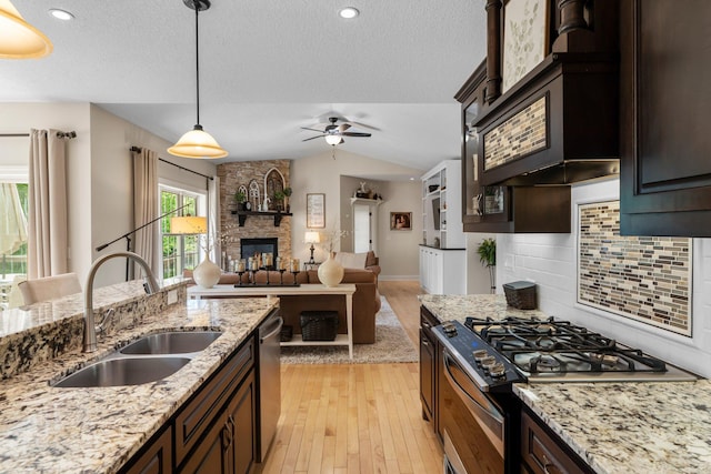 855 Elins Lake Rd SE, Cambridge, MN 55008 - kitchen featuring a sink, stainless steel appliances, ceiling fan, a stone fireplace, and light wood finished floors