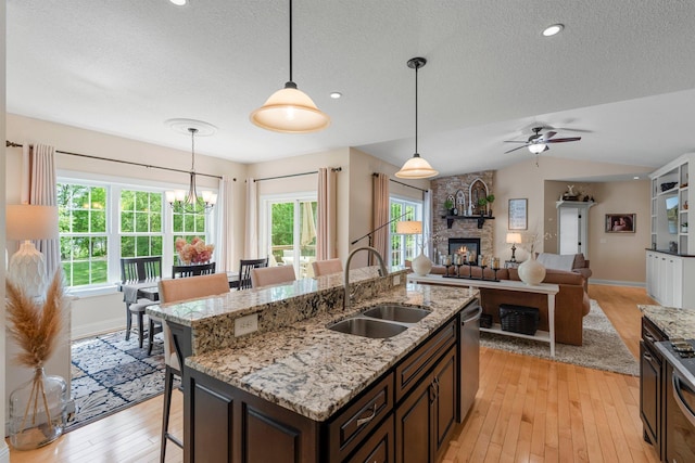 855 Elins Lake Rd SE, Cambridge, MN 55008 - kitchen with a sink, a breakfast bar, light wood-style flooring, a textured ceiling, and appliances with stainless steel finishes