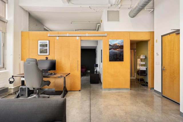 office area featuring a high ceiling and concrete flooring