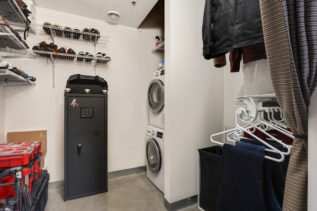 laundry room featuring stacked washing machine and dryer and baseboards