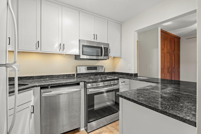 4820 Park Commons Dr Unit 329, Saint Louis Park, MN 55416 - kitchen with appliances with stainless steel finishes, white cabinets, dark stone counters, and a peninsula