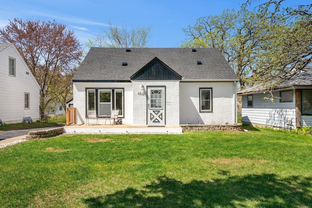 4528 6th St NE, Columbia Heights, MN 55421 - rear view of property featuring a yard, a shingled roof, and stucco siding