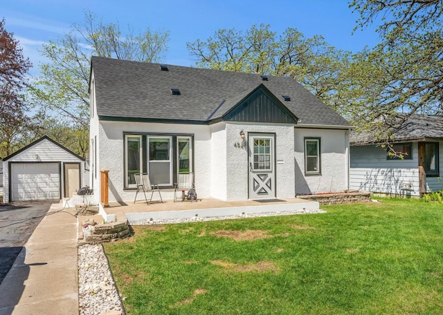 4528 6th St NE, Columbia Heights, MN 55421 - view of front of house featuring an outbuilding, roof with shingles, a front lawn, and asphalt driveway