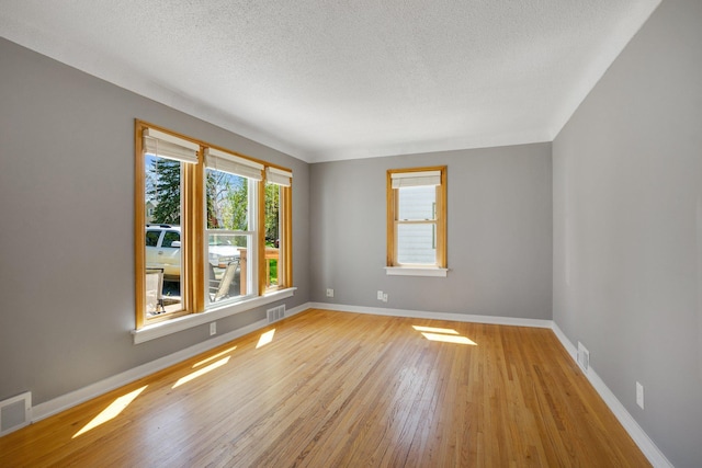 4528 6th St NE, Columbia Heights, MN 55421 - unfurnished room with a textured ceiling, light wood-style flooring, and baseboards