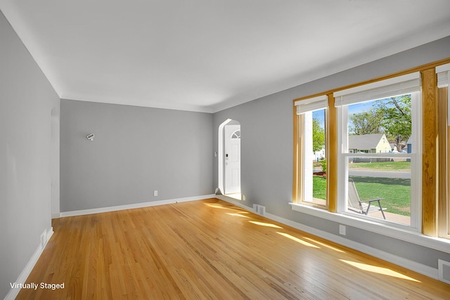 4528 6th St NE, Columbia Heights, MN 55421 - unfurnished room featuring arched walkways, light wood finished floors, and baseboards
