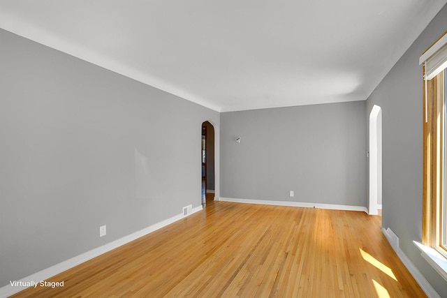4528 6th St NE, Columbia Heights, MN 55421 - empty room with arched walkways, light wood finished floors, and baseboards