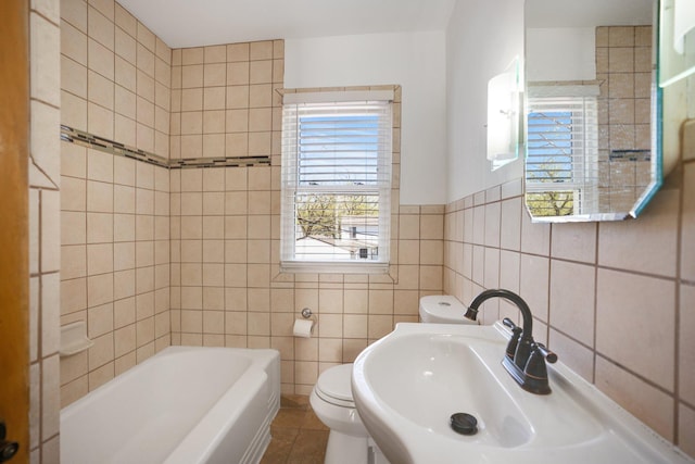 4528 6th St NE, Columbia Heights, MN 55421 - bathroom with toilet, a bathtub, tile walls, a sink, and tile patterned flooring