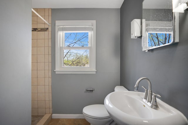 4528 6th St NE, Columbia Heights, MN 55421 - full bath with a sink, a tile shower, toilet, baseboards, and tile patterned floors