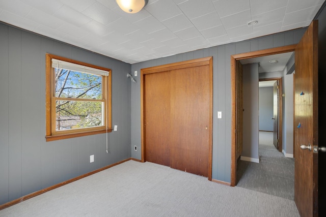 4528 6th St NE, Columbia Heights, MN 55421 - unfurnished bedroom featuring carpet, a closet, baseboards, and wooden walls