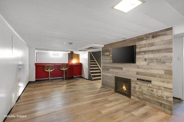 4528 6th St NE, Columbia Heights, MN 55421 - basement featuring a bar, wood finished floors, stairway, wooden walls, and a glass covered fireplace
