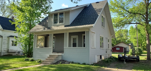 217 Flynn St, Redwood Falls, MN 56283 - bungalow featuring a front lawn, roof with shingles, and covered porch