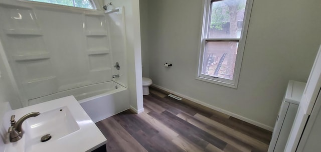 217 Flynn St, Redwood Falls, MN 56283 - full bath featuring toilet, wood finished floors, vanity, baseboards, and shower / tub combination