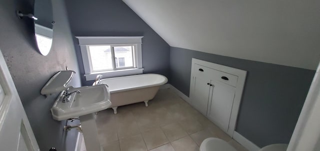 217 Flynn St, Redwood Falls, MN 56283 - full bath with vaulted ceiling, tile patterned floors, toilet, a freestanding tub, and baseboards