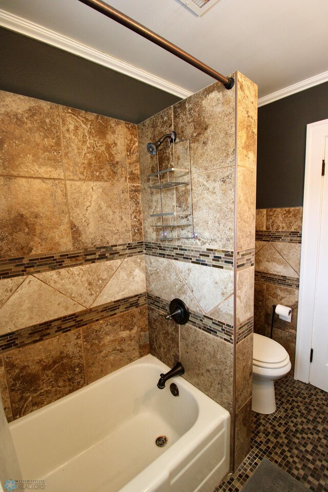 full bathroom featuring toilet, bathtub / shower combination, crown molding, tile walls, and tile patterned flooring