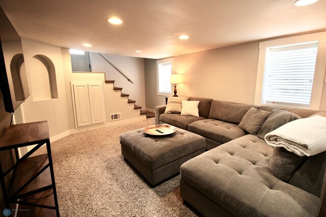 carpeted living area with recessed lighting, stairway, and baseboards