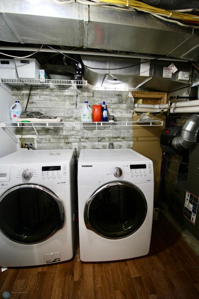 clothes washing area featuring washer and dryer and wood finished floors
