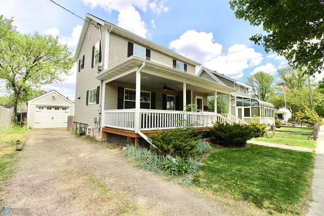 country-style home with an outdoor structure, covered porch, a ceiling fan, driveway, and a garage