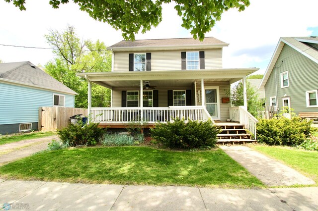 view of front of home with a porch, ceiling fan, and a front yard